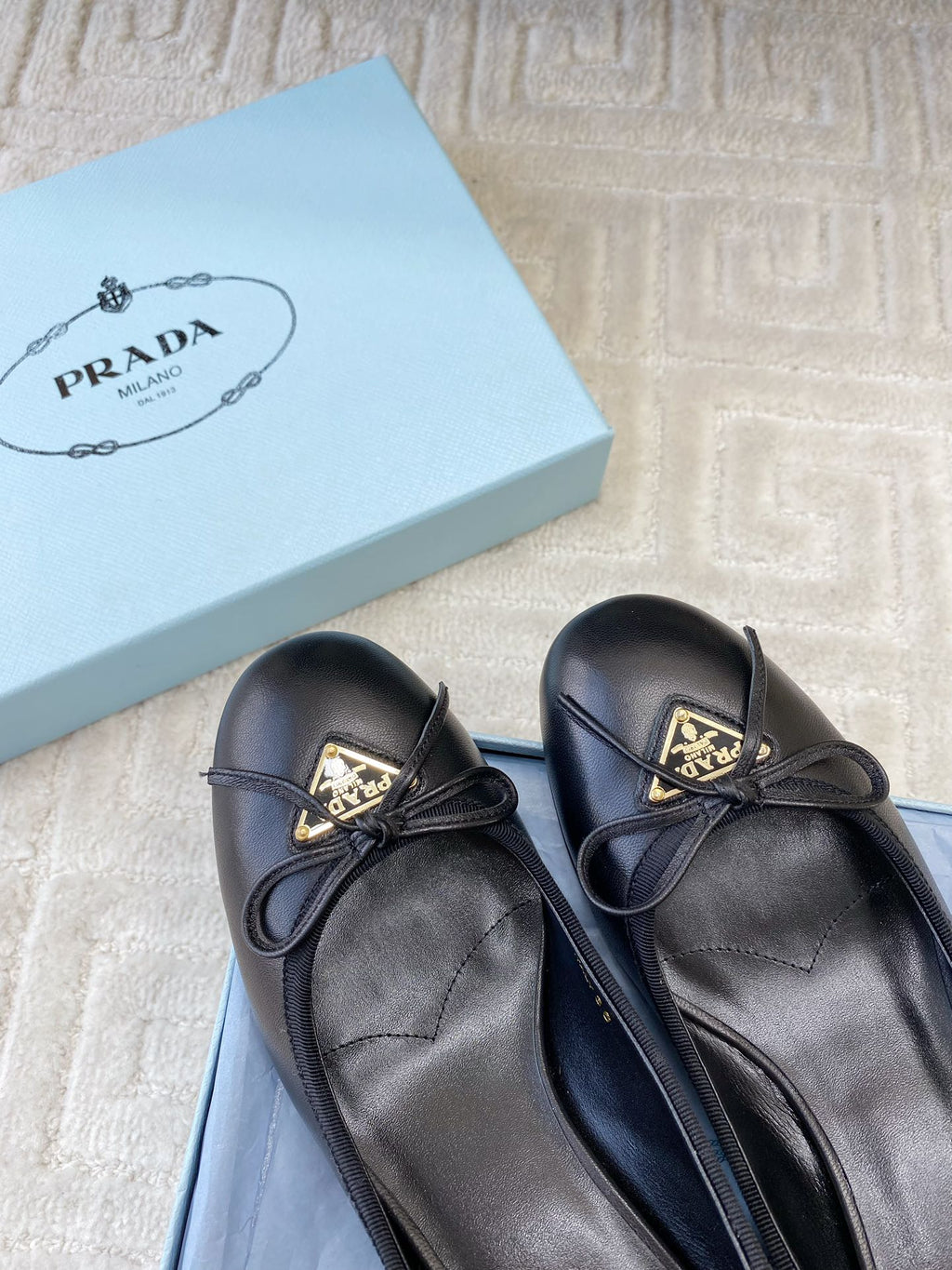 BALLERINA PUMPS WITH TRIANGLE LOGO AND BOW IN BLACK CALFSKIN